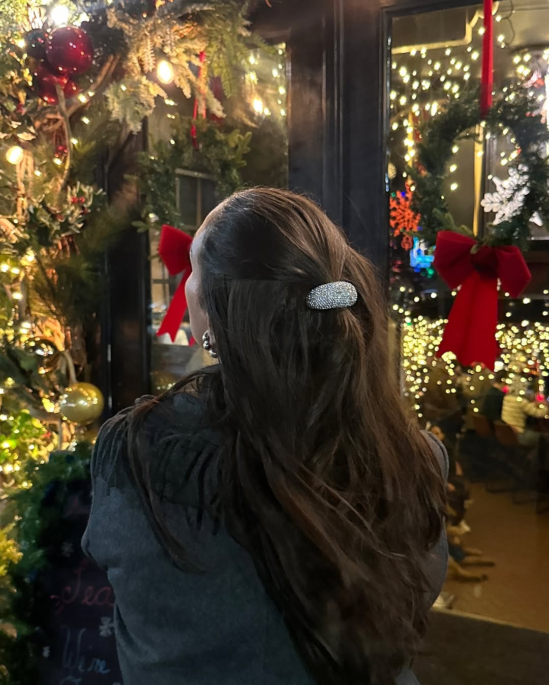 person with dark brunette hair wearing a crystal ponytail cuff