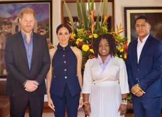 Meghan Markle stands with Prince Harry and the Colombian vice president while wearing a veronica beard suit