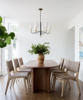 dining room with white walls woven chairs and oval wooden table