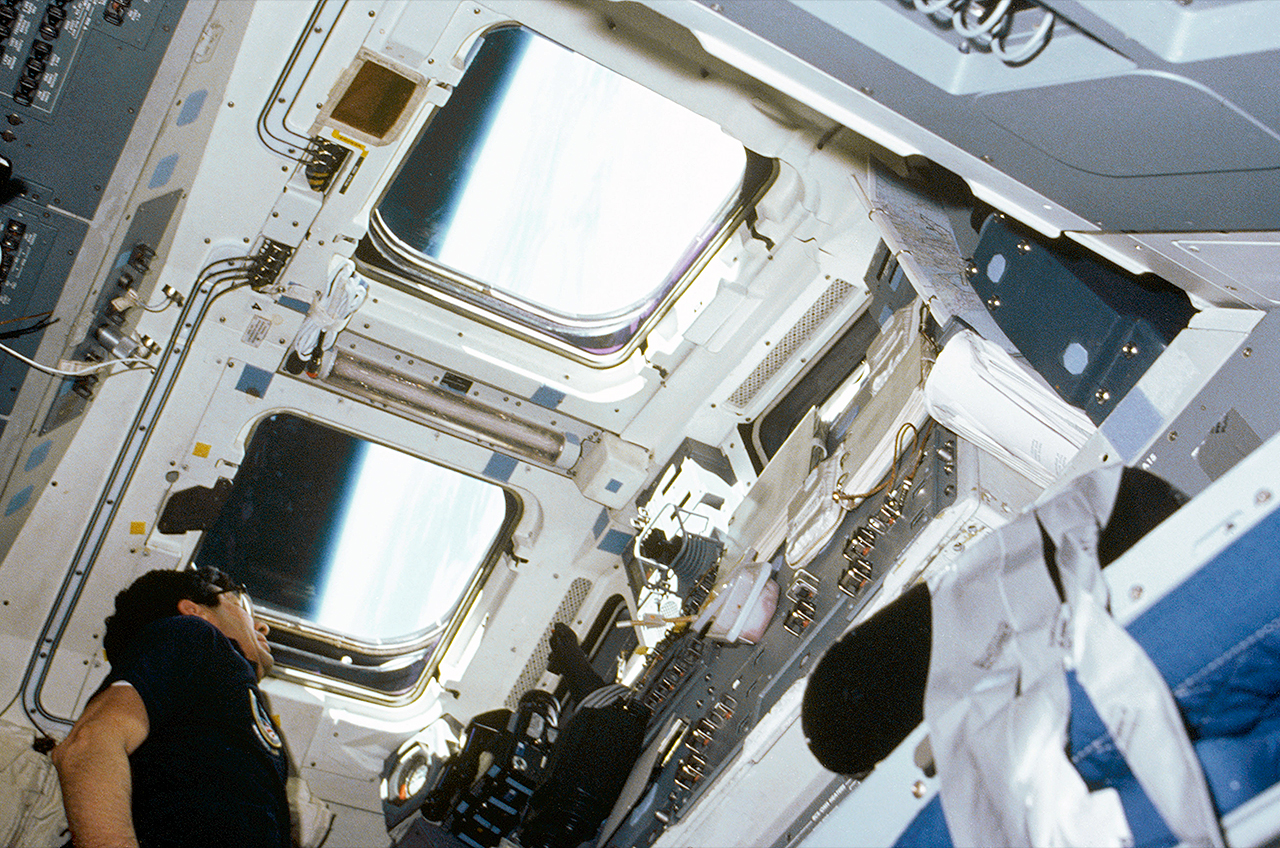 In this low-angle photo, STS-51B payload specialist Lodewijk van den Berg looks out aft flight deck window aboard space shuttle Challenger.