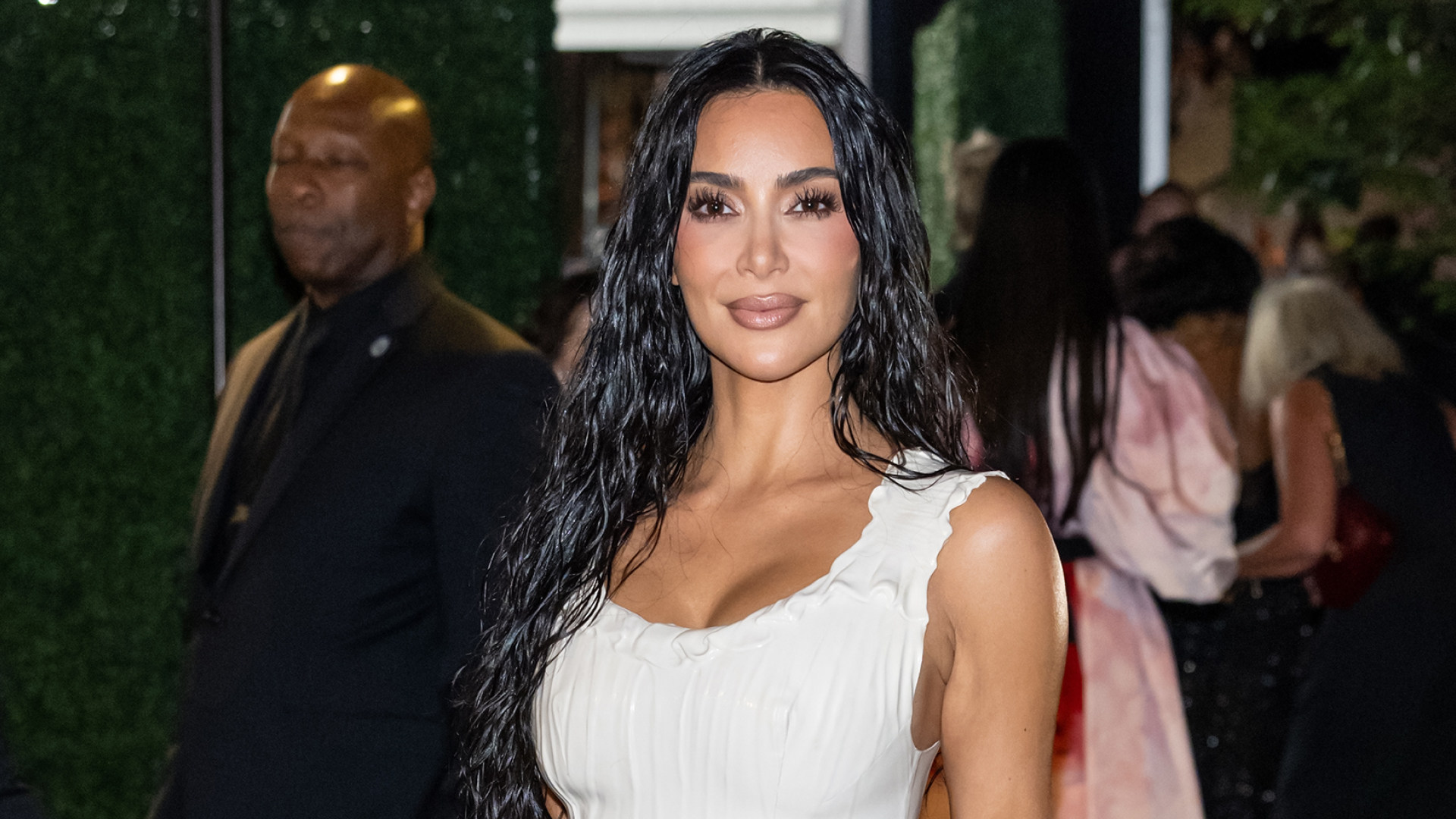 Kim Kardashian wearing a white dress and long wet-looking hair.