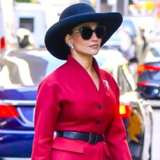 Jennifer Lopez was spotted on the set of her new movie wearing a burgundy skirt set, a croc-embossed bag, a hat, and checkered Mary Janes