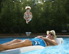 Grandparent relaxing in the pool with his grandson