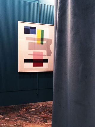 Colourful artwork on a wall behind a curtain