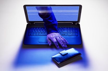 Hand of hacker reaching for wallet from screen of laptop