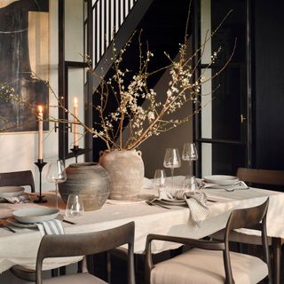 Dining table with a vase of flowers and lit candles