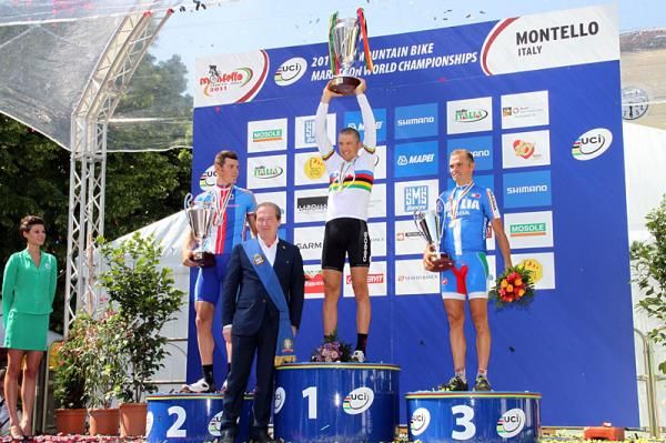 Christoph Sauser (Switzerland) holds up the winner's trophy