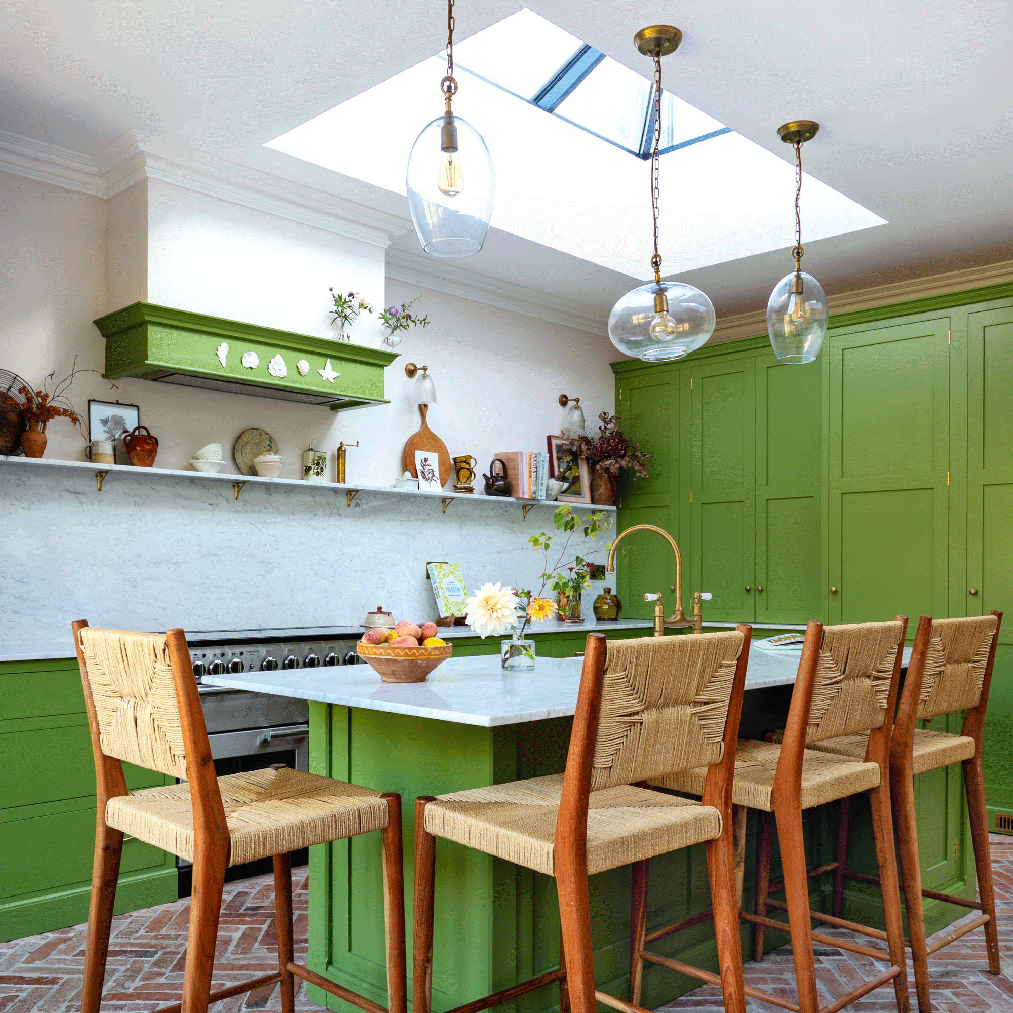 a green shaker kitchen with open shelving and herringbone flooring, a large kitchen island with breakfast bar and four bar stools
