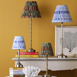 4 table lamps with patterned shades on a console table