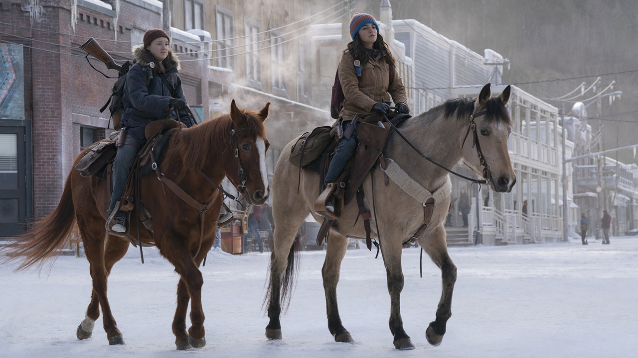 Ellie and Dina riding on horseback in the snow in The Last of Us season 2