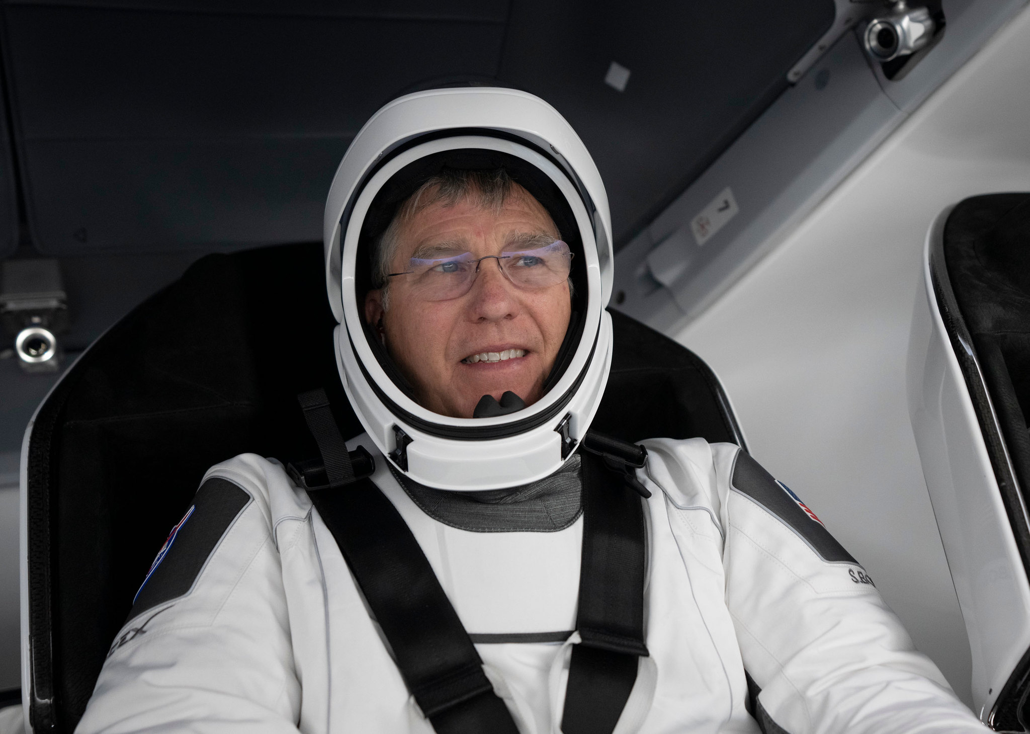 NASA astronaut Stephen Bowen sitting down in a spacecraft with a seatbelt