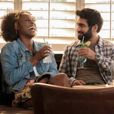 issa rae and kumail nanjiani laughing in a booth in a still from the movie the lovebirds