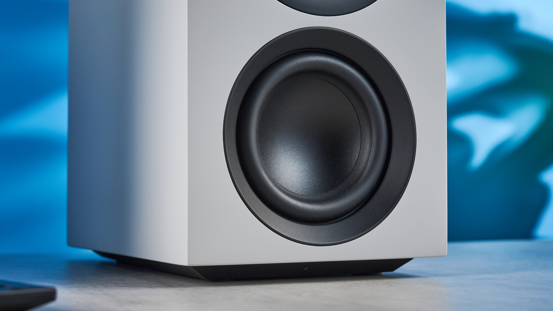 the cambridge audio l/r s bookshelf speakers in white with a 21mm aluminum tweeter and a 3-inch woofer photographed against the blue tom's guide background