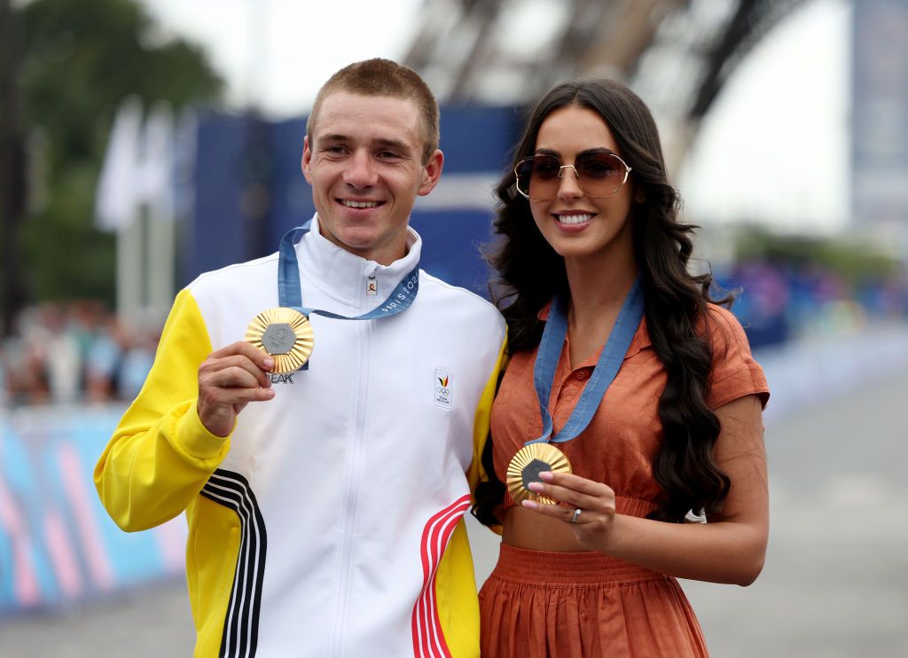 PARIS FRANCE AUGUST 03 Gold medalist Remco Evenepoel of Team Belgium and his wife Oumaima Oumi Rayane pose on the podium with his gold medals of Individual Time Trial and Road race during the Mens Road Race on day eight of the Olympic Games Paris 2024 at trocadero on August 03 2024 in Paris France Photo by Tim de WaeleGetty Images