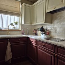 kitchen with dark red lower cabinets and cream upper cabinets