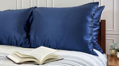 Dark blue copper-infused pillowcases from Copper North on a bed