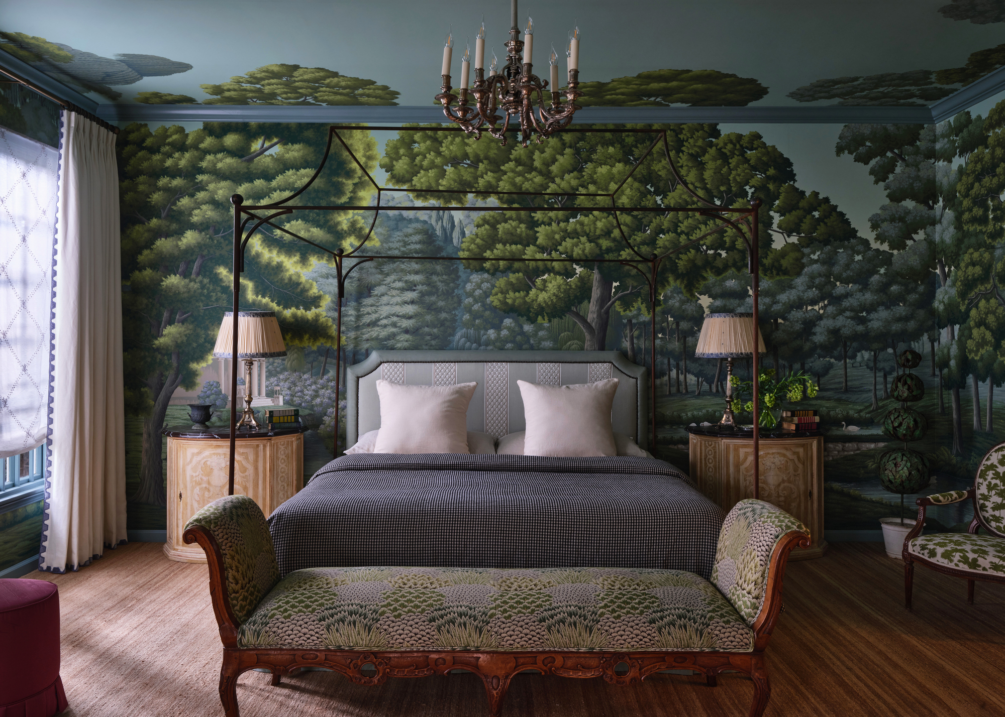 A bedroom with a four-poster bed and a large-scale botanical mural on the walls and ceiling