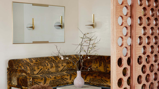 A cozy corner in a home with a mirror and wall sconce