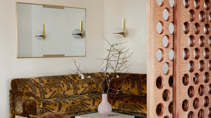 A cozy corner in a home with a mirror and wall sconce