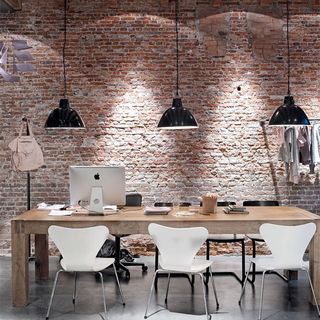 dining area with brick wall and wooden dining table