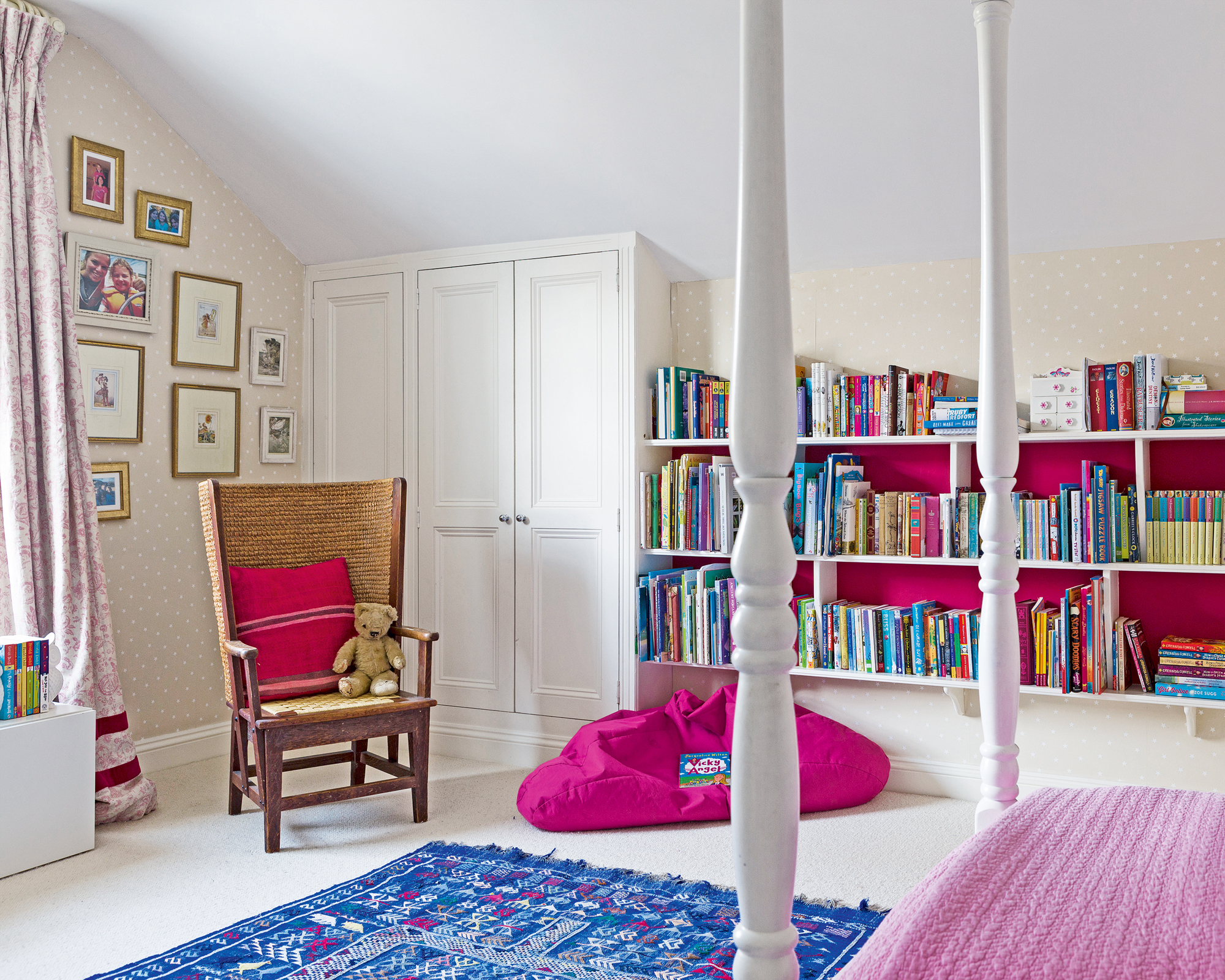 Bedroom ideas for girls with four poster bed, pink beanbag, bookshelves and gallery wall.