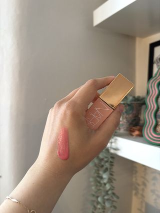 Mica Ricketts mostrando una muestra de NARS Afterglow Liquid Blush en Orgasm