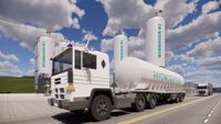 white hydrogen tank truck in front of two hydrogen storage tanks.