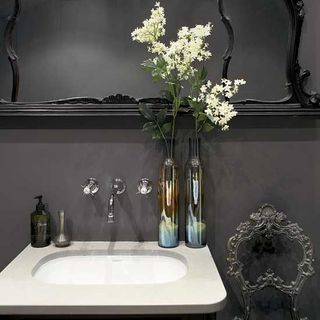 grey bathroom with washbasin and flower bottle