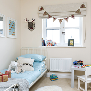 children bedroom with white wall and toys on bed