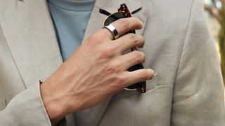 Person wearing Oura Ring putting sunglasses into their pocket