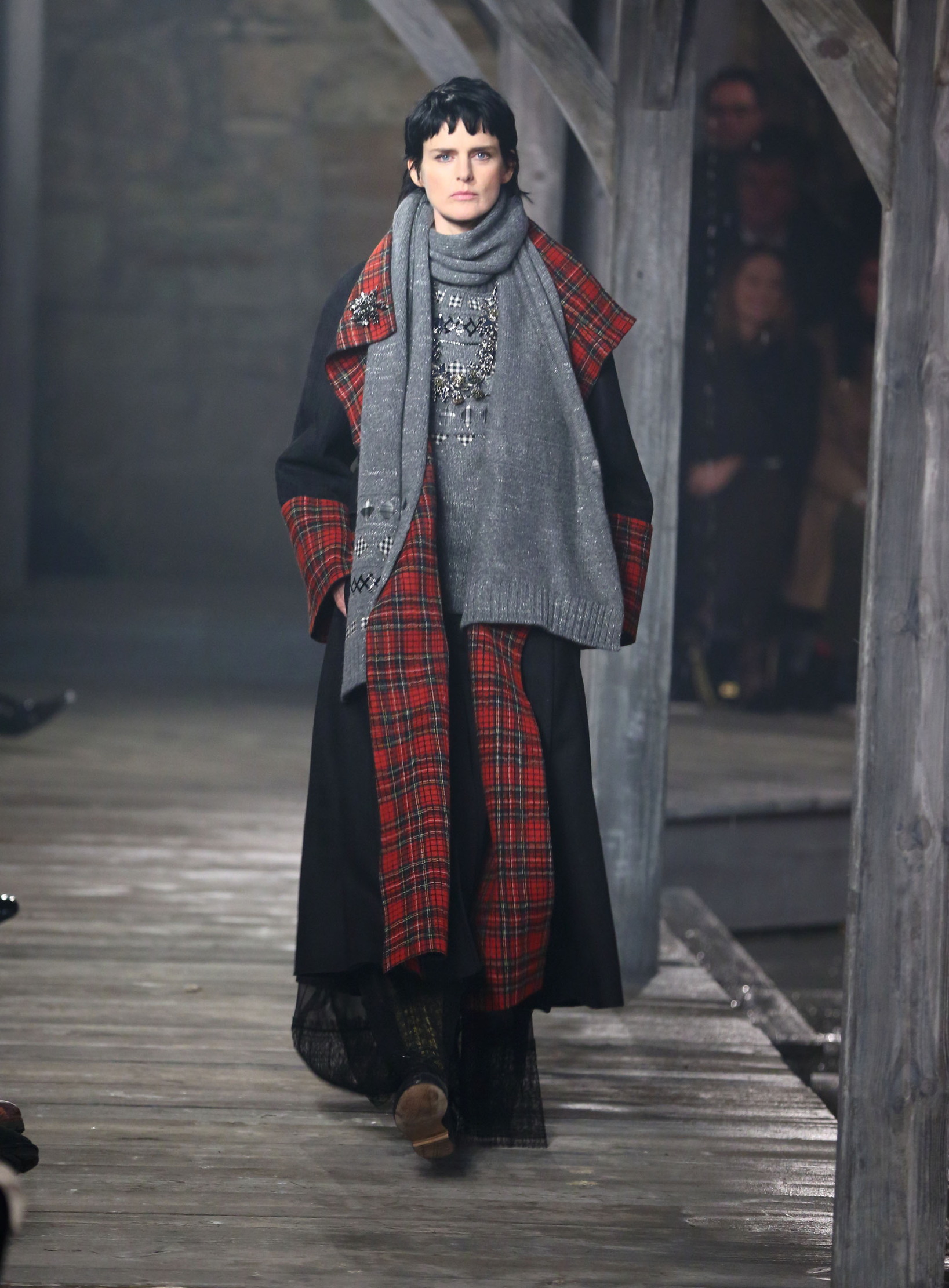 A woman walks down the Chanel catwalk wearing tweed
