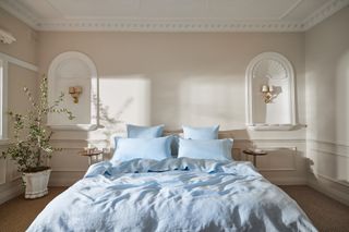 A neutral bedroom with a bed in light blue bedding