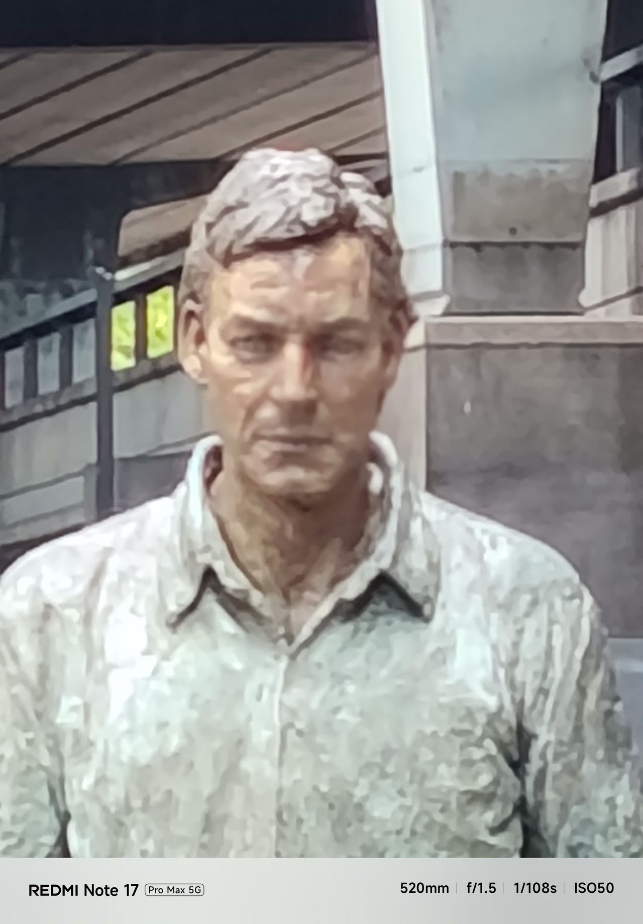 Tightly cropped, soft-looking close-up of the walking man sculpture&rsquo;s face at 20x digital zoom.