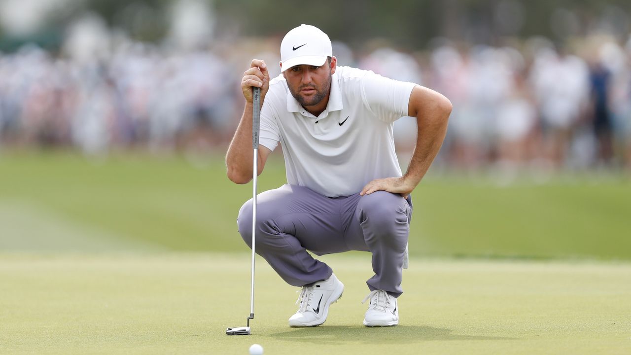 Scottie Scheffler crouches down behind a putt during R3 of the 2024 Houston Open