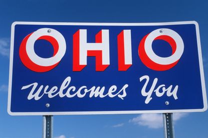 A sign that reads "Welcome to Ohio" against a blue sky