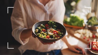 Woman holding up a bowl of salad complete with leafy greens, eggs and vegetables, a recipe for learning how to lose weight in a week