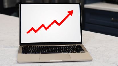 A MacBook screen showing a red arrow rising