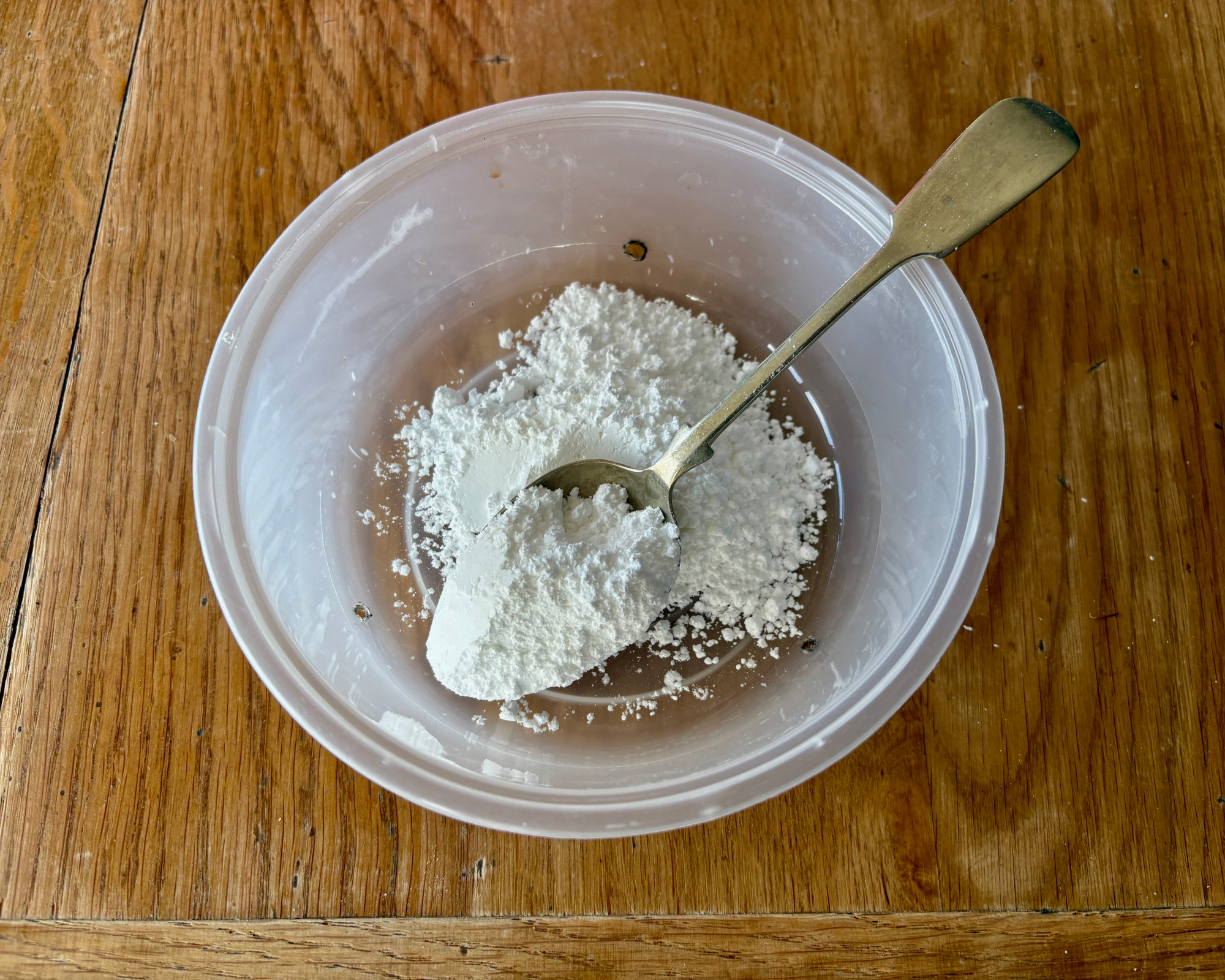adding baking soda and icing sugar to a natural homemade ant trap