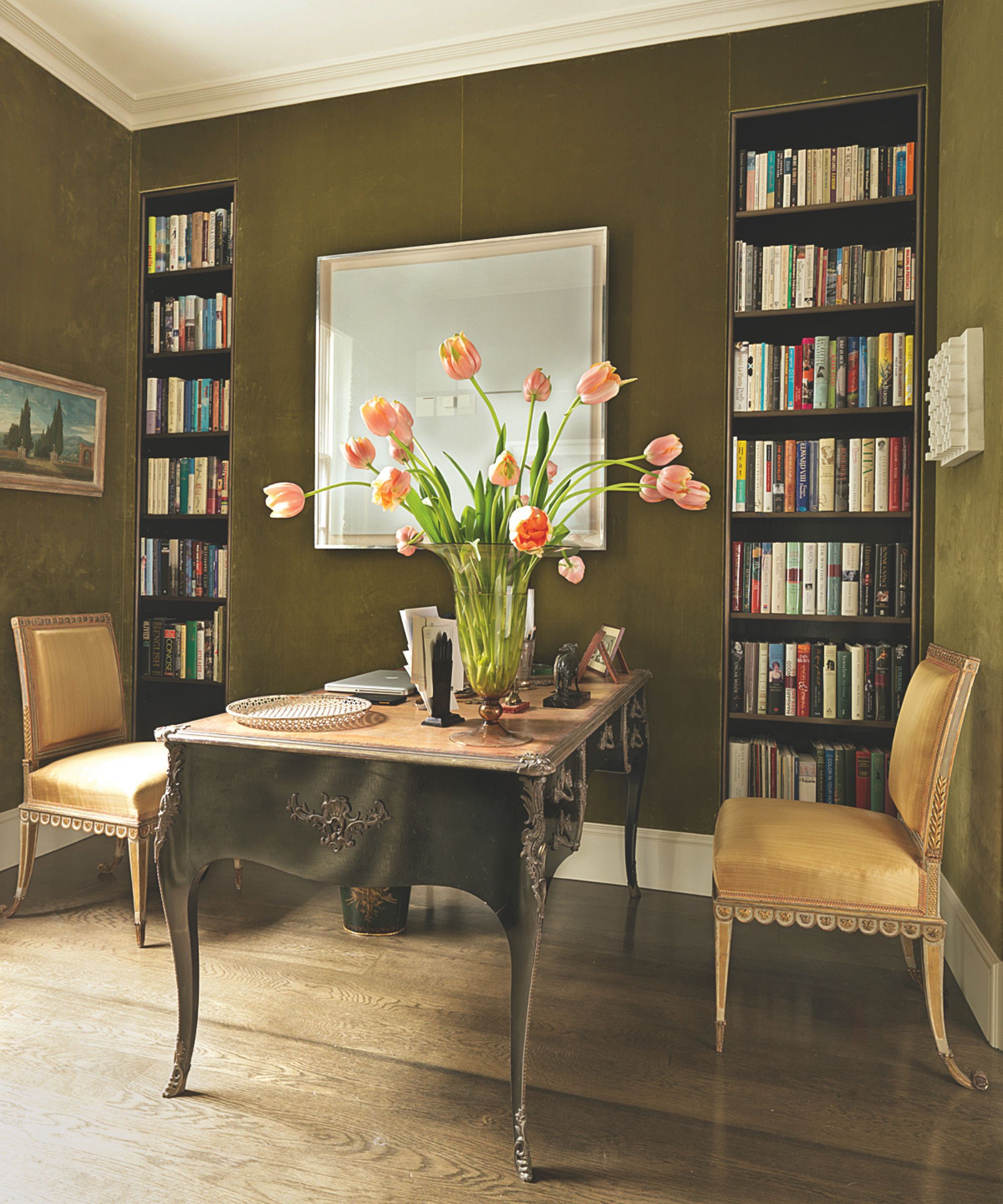 office with green velvet walls and inbuilt book shelves and desk with two chairs