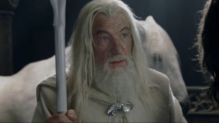 Gandalf looking with wide eyes while holding his staff.