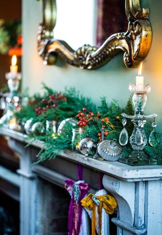 mantelpiece decorated for Chrsitmas with greenery and vintage baubles