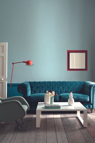 blue velvet sofa in light blue living room