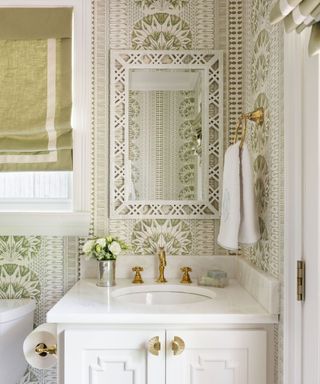 white sink in bathroom with green patterned wallpaper