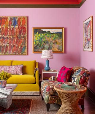 A pink living room with layered patterns and a bright yellow couch