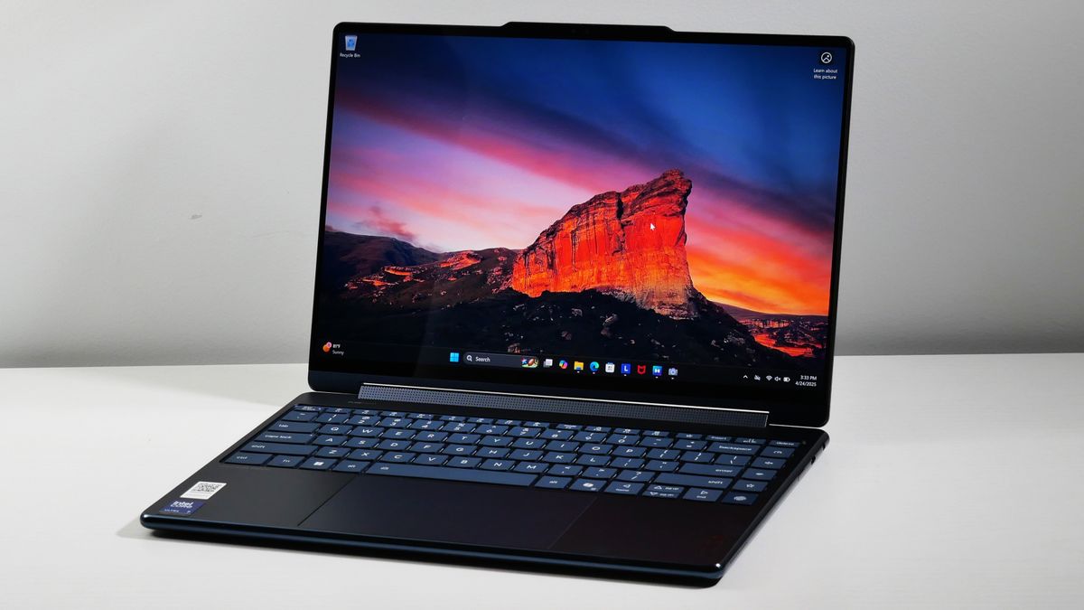 Lenovo Yoga 9i 2-in-1 Aura Edition open at an angle on a white desk.