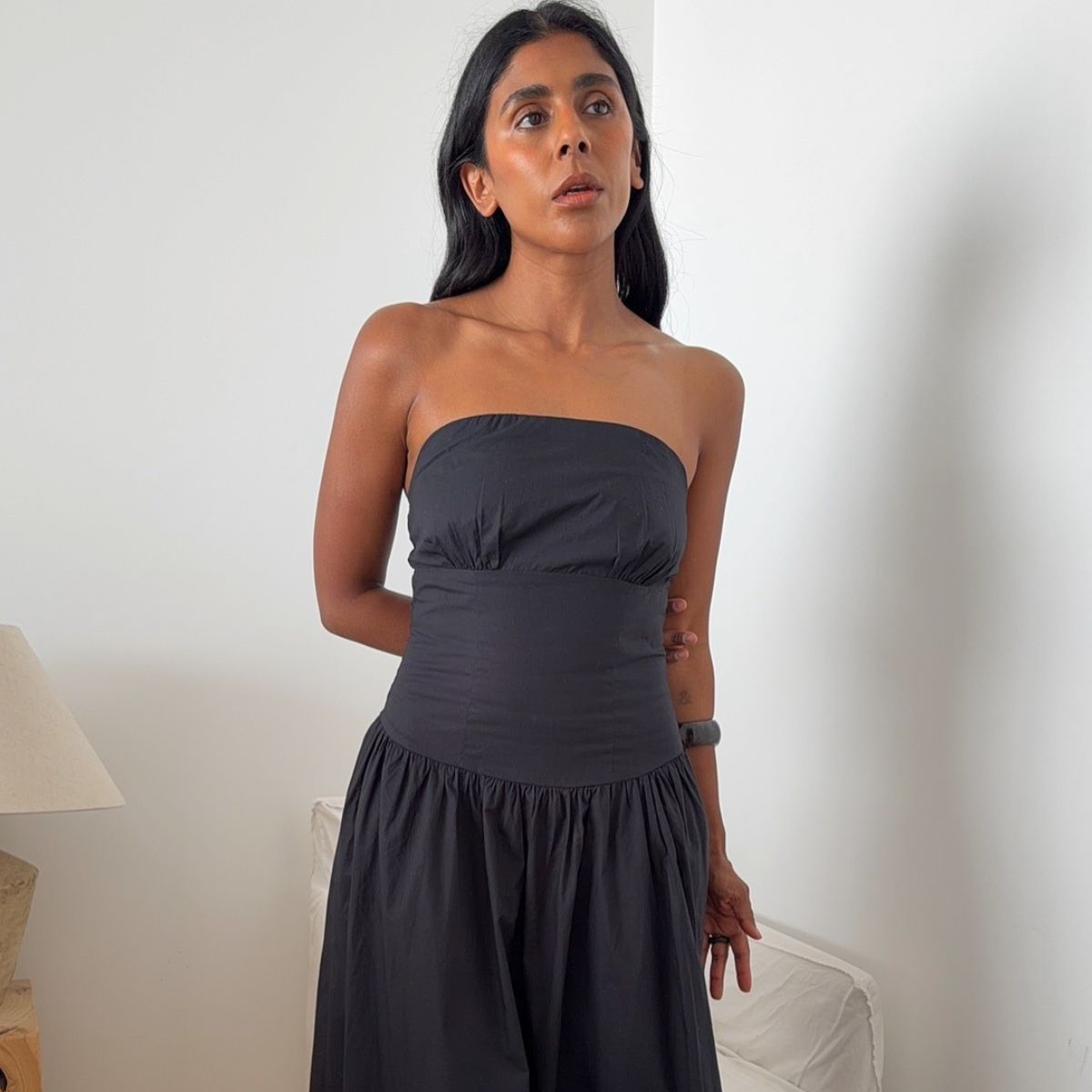 Monikh wearing black strapless dress