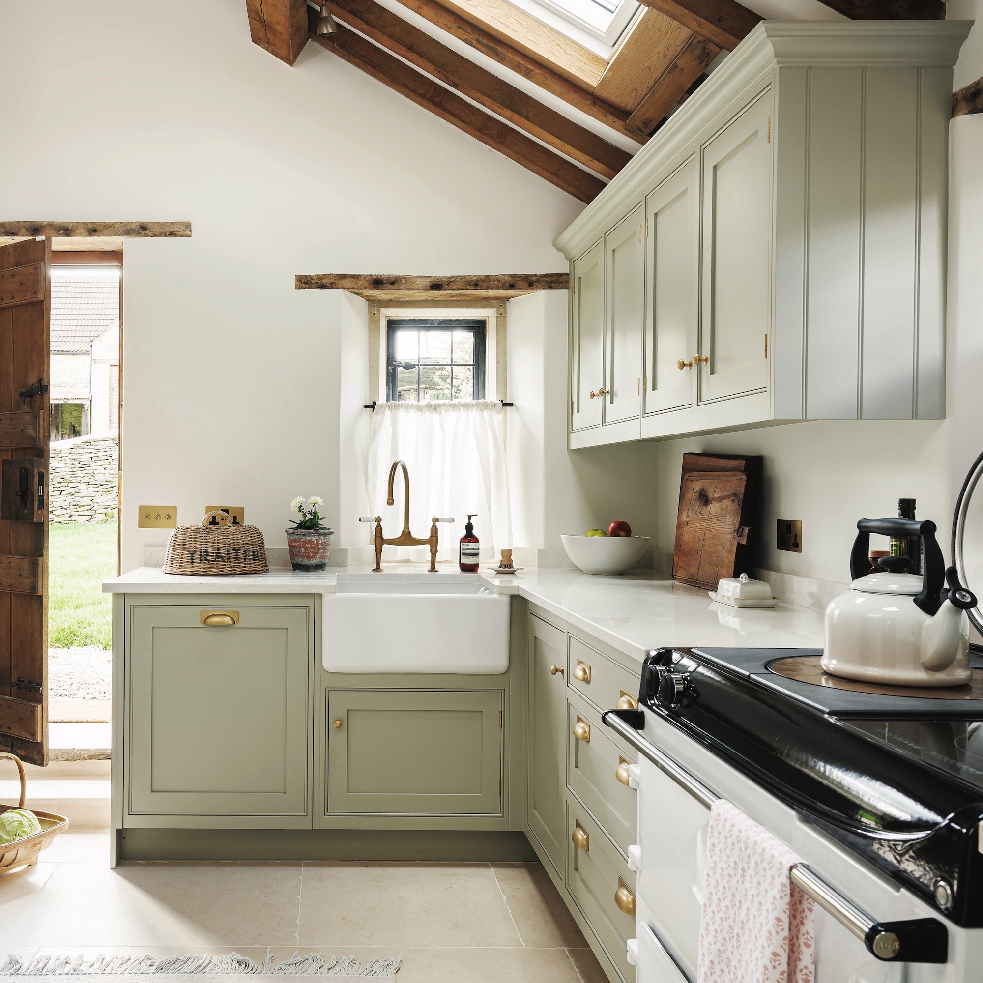country style kitchen with pale sage green shaker cabinets and white butler sink