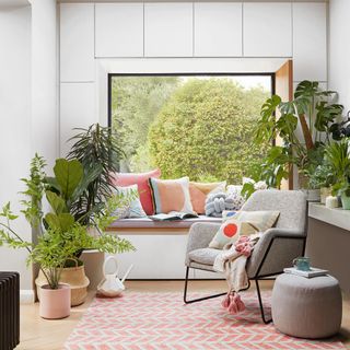 Living room with window seat surrounded by houseplants
