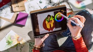 The best tablets with a stylus pen for drawing and note-taking; a photo of a woman drawing on a tablet