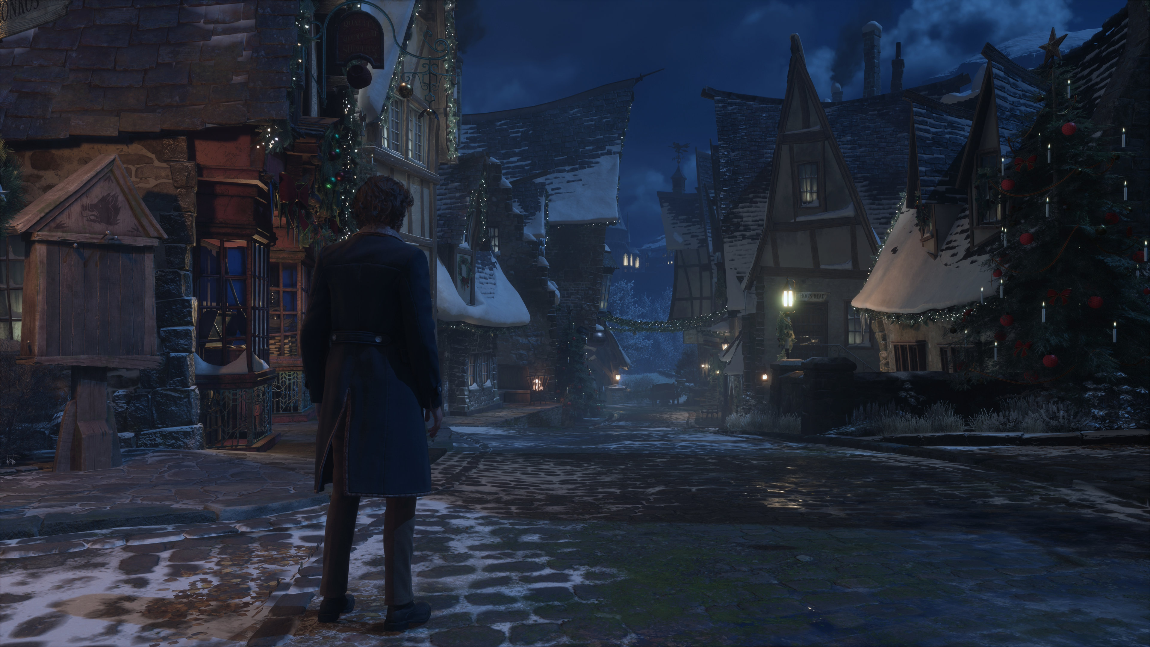 A screenshot of the PC version of Hogwarts Legacy, showing a night time view of Hogsmeade